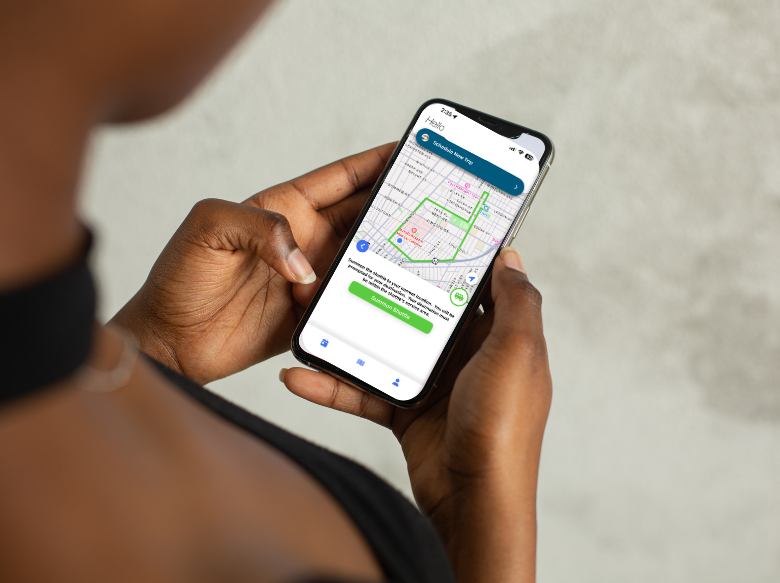 The image shows a user with the All Access app open on their cell phone preparing to schedule a trip on the All Access system.